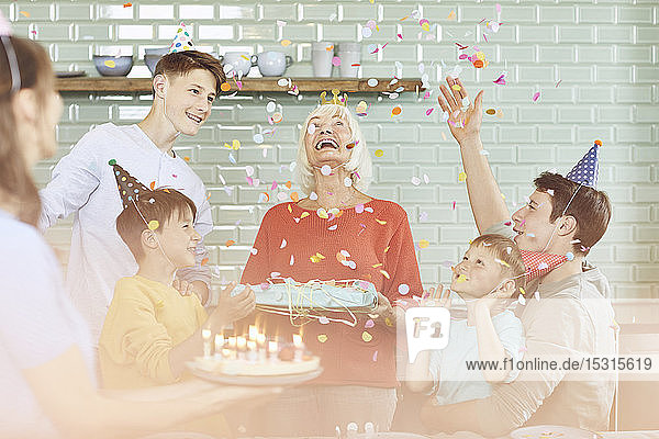 Mother and sons celebrating grandmother's bithday in their kitchen