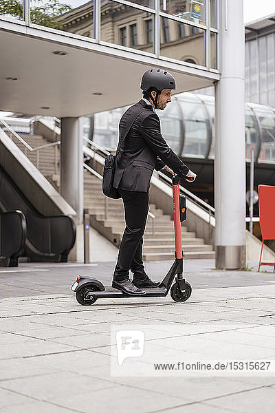 Businessman riding e-scooter in the city