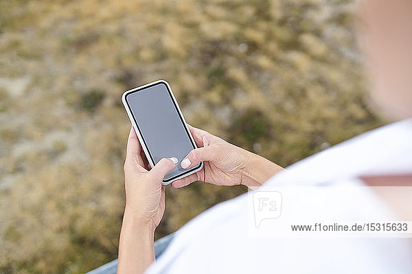 Nahaufnahme einer Frau  die ein Smartphone im Freien benutzt