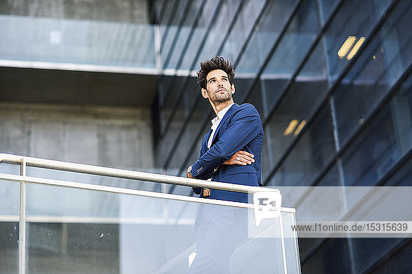 Geschäftsmann steht auf dem Balkon eines Bürogebäudes