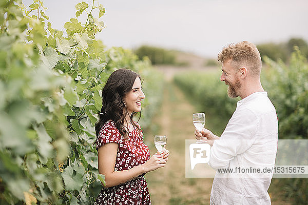 Ehepaar trinkt Weißwein in den Weinbergen
