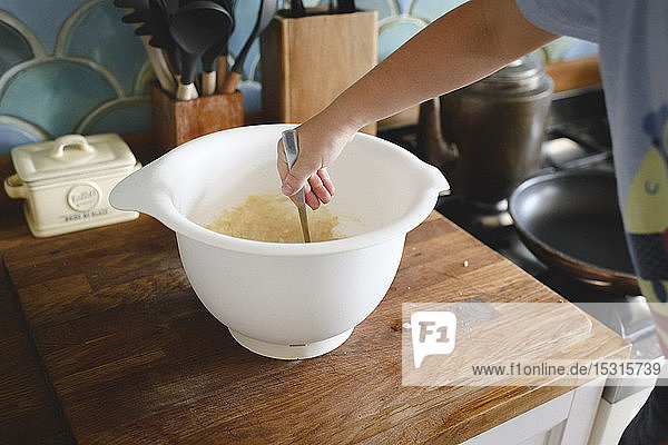 Boy's hand mixing pancake dough in the kitchen