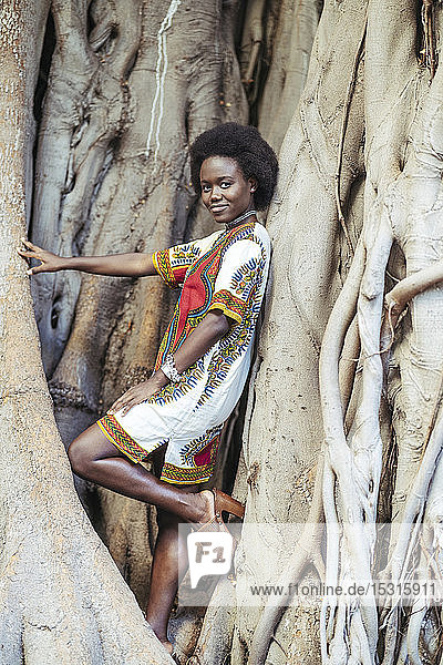 Junge Frau posiert in einem Baumstamm