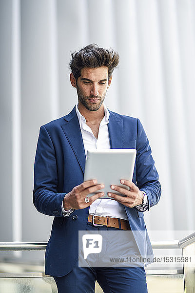 Businessman using tablet outdoors in the city