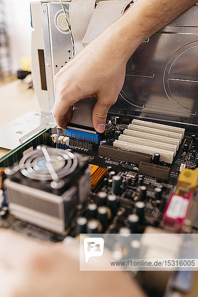 Nahaufnahme eines Technikers  der einen Desktop-Computer repariert und die internen Anschlüsse überprüft