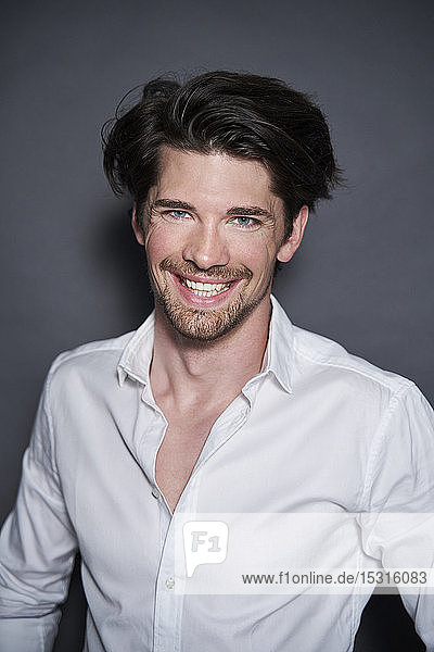 Portrait of smiling handsome man wearing white shirt