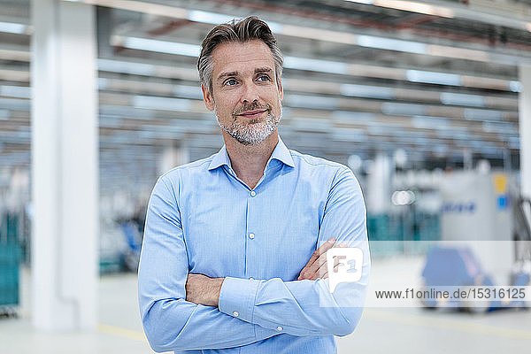 Porträt eines selbstbewussten Geschäftsmannes in einer Fabrikhalle