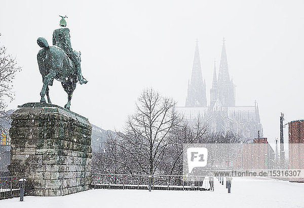 Statue Kaiser Wilhelms II. gegen den Kölner Dom im Winter in der Stadt