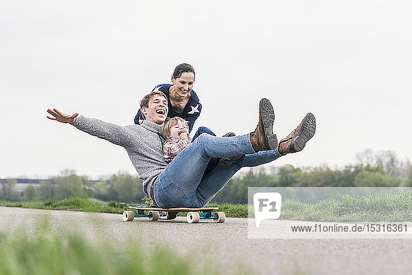 Vater und Sohn amüsieren sich  spielen mit dem Skateboard im Freien