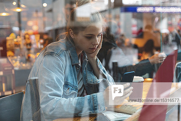 Young woman in a cafe using a smartphone