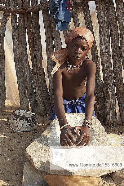 Mucubal tribe girl grinding maize in the traditional way  Tchitundo Hulo  Virei  Angola