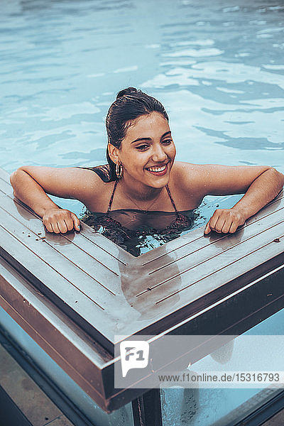 Porträt einer glücklichen jungen Frau im Schwimmbad