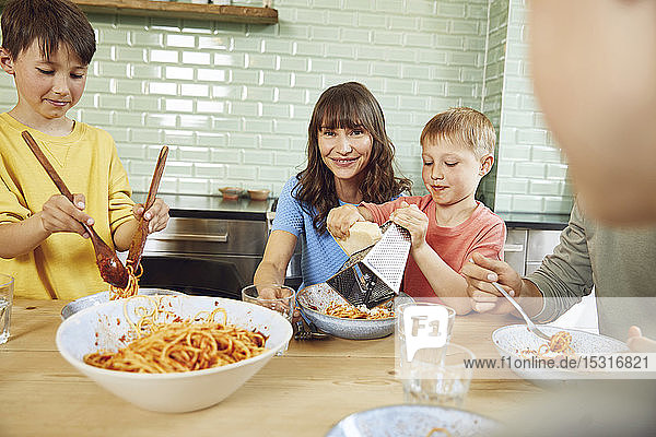 Mutter isst Spaghetti mit ihren Söhnen in der Küche