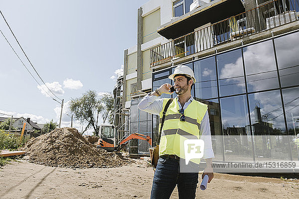 Architekt mit Telefon auf der Baustelle