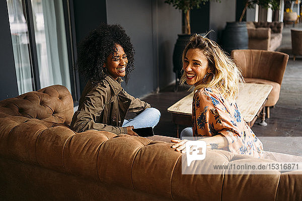 Multikulturelle Frauen sitzen auf einem Sofa in einem Cafe