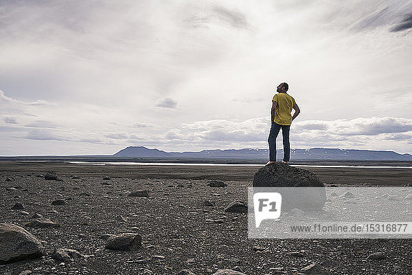 Erwachsener Mann steht auf einem Felsen im vulkanischen Hochland von Island