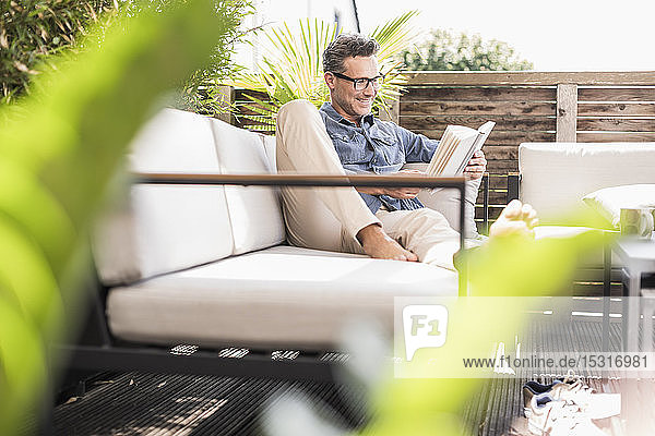 Confident man relaxing on the terrace reading book