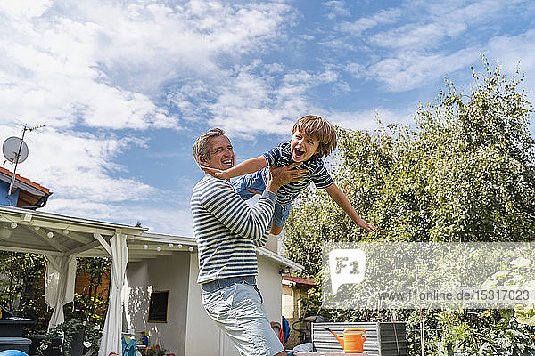 Father playing with son in garden
