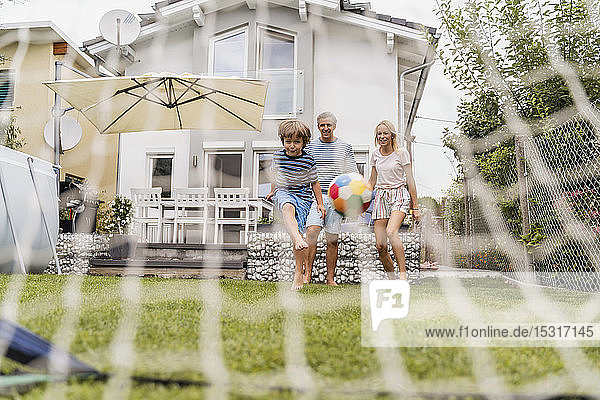 Happy family playing football in garden