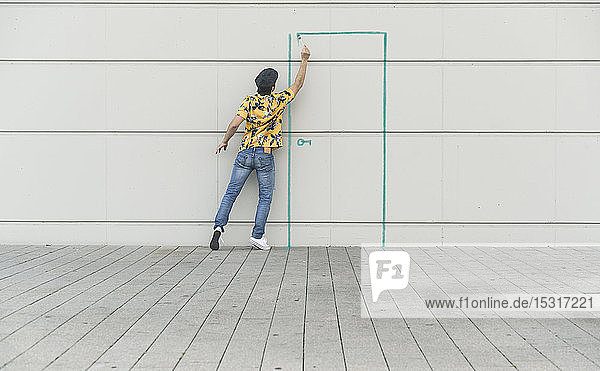 Digital composite of young man drawing a door at a wall