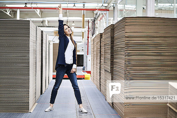 Portrait of excited businesswoman in factory warehouse