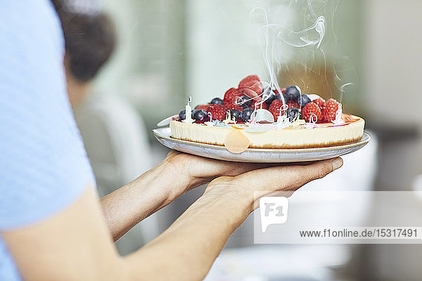 Woman serving berry cake at birthday party