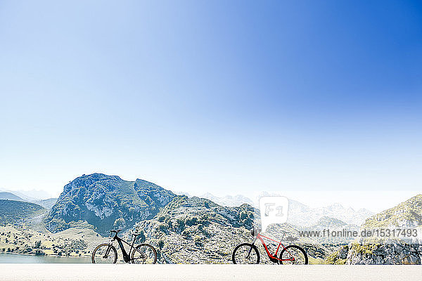 Two all terrain bicycles next to the mountains in Lagos de Covadonga  Asturias  Spain