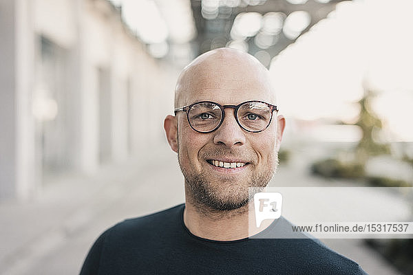 Portrait of smiling bald man wearing glasses