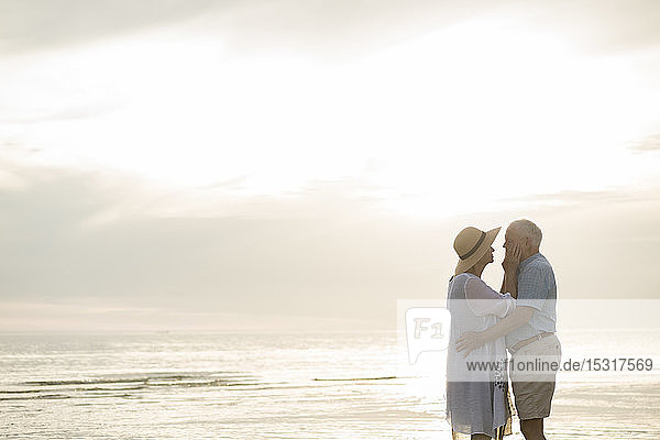 Senior couple standing face to face on the beach by sunset  Liepaja  Latvia