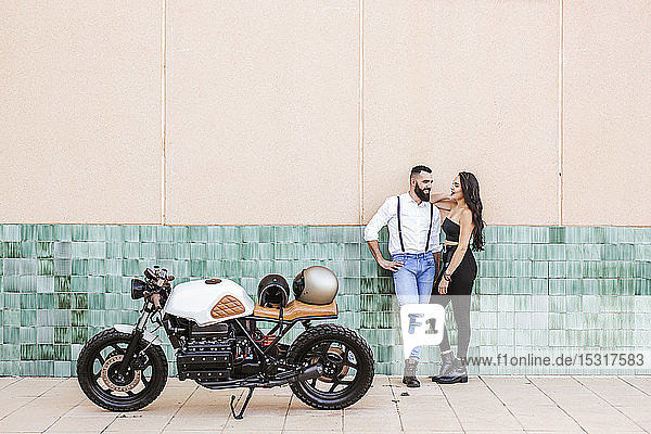 Couple with parked motorbike