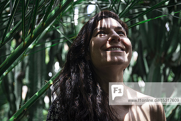 Porträt einer lächelnden Frau an einer Palme  Fuerteventura  Spanien