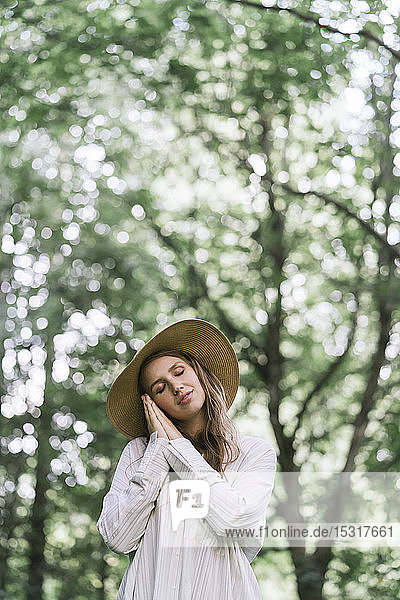 Junge Frau mit Hut genießt den Wald