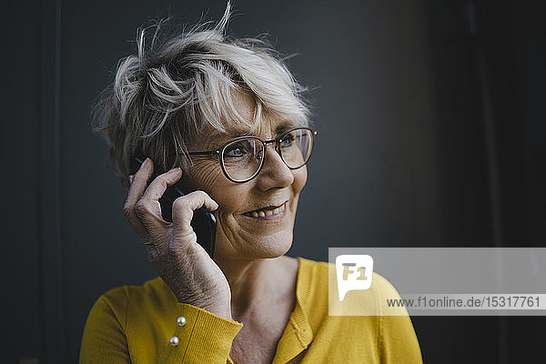 Porträt einer reifen Geschäftsfrau mit grauen Haaren am Telefon