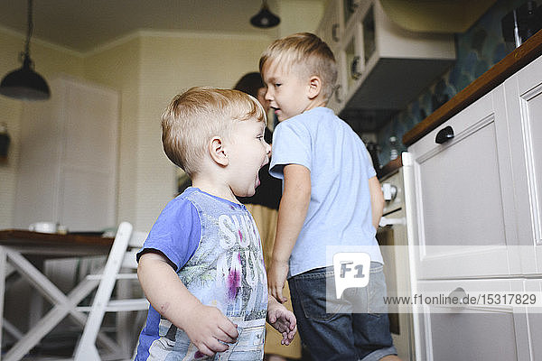 Zwei kleine Jungen rennen in die Küche