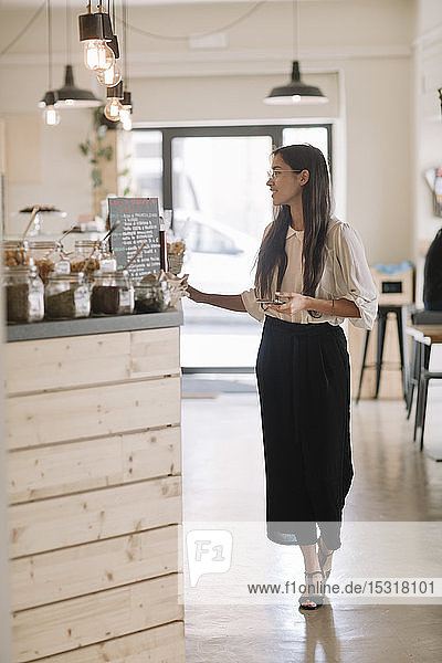 Young woman standing at the counter in a cafe