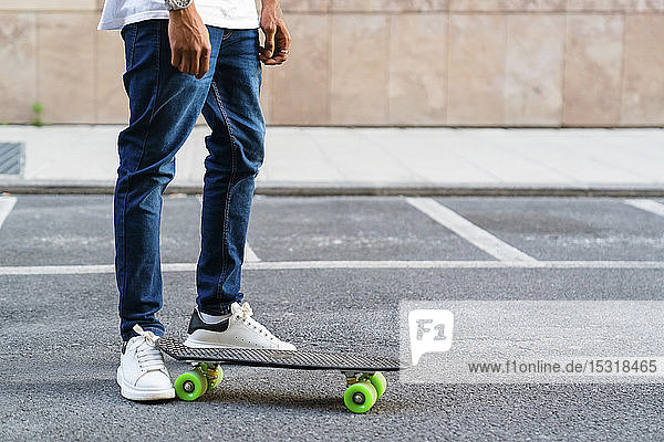Beine eines jungen Mannes mit Skateboard