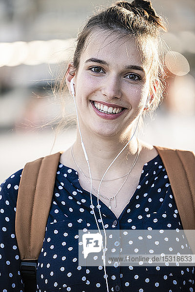 Porträt einer lächelnden jungen Frau mit Kopfhörern