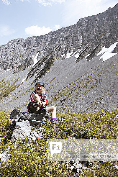 Mädchen macht während einer Wanderung in den Bergen eine Pause