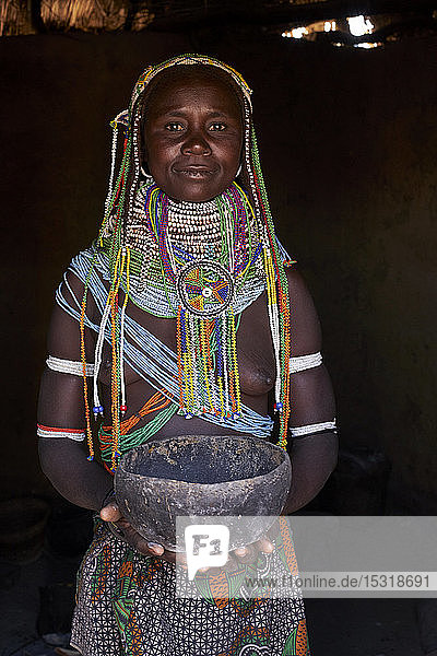Portrait of a Muhila traditional woman standing in her house  holding pot  Congolo  Angola