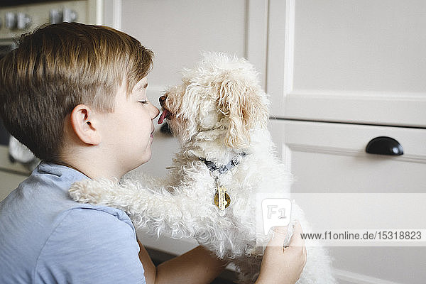 Boy playing with his dog at home