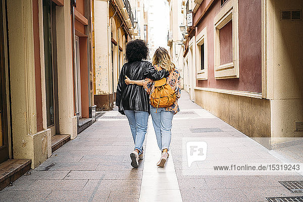 Rückansicht von multikulturellen Frauen  die in der Stadt spazieren gehen  Almeria  Spanien