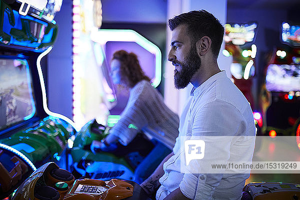 Mann an einem Fahrsimulator in einer Spielhalle