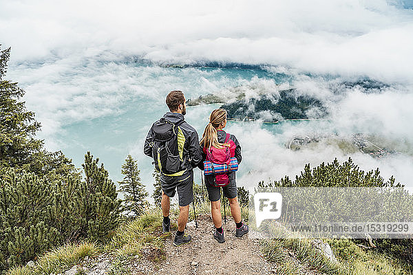 Young couple on a hiking trip in the mountains looking at view  Herzogstand  Bavaria  Germany