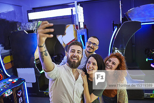 Glückliche Freunde  die in einer Spielhalle ein Selfie machen
