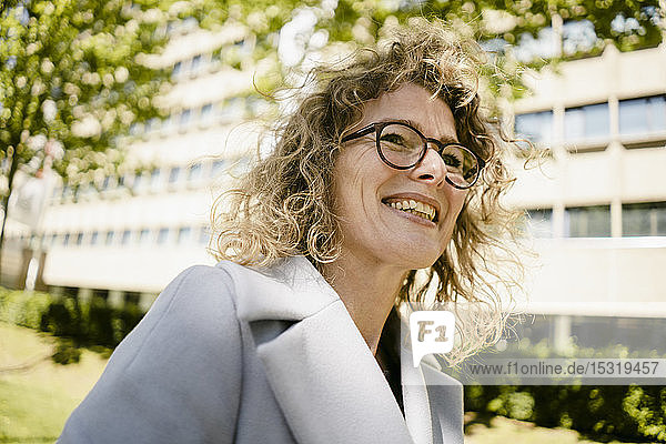 Porträt einer lachenden reifen Geschäftsfrau mit Brille im Freien