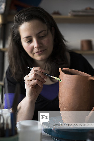 Töpferin bemalt unvollendete Vase in ihrer Werkstatt