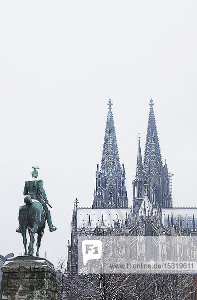 Niedrigwinkelansicht der Kaiser-Wilhelm-II-Statue gegen den Kölner Dom im Winter in der Stadt