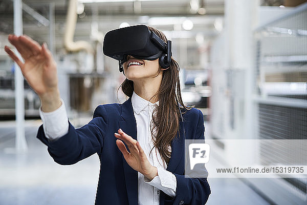 Geschäftsfrau mit VR-Brille in der Fabrik