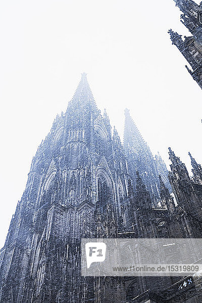 Niedrigwinkelansicht des historischen Kölner Doms in der Stadt bei Schneefall gegen den Himmel