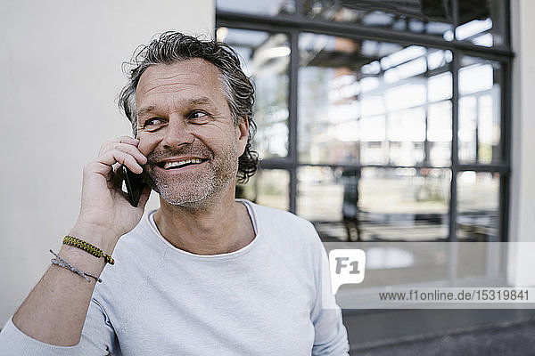 Smiling mature man using smartphone